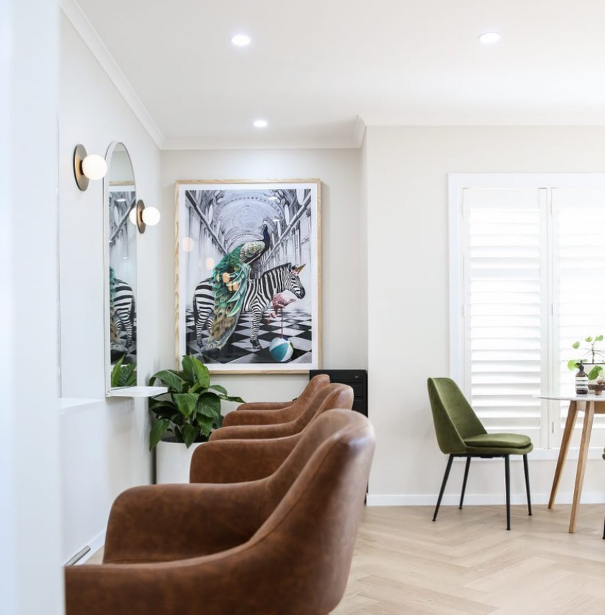 Waiting area at Arlo & Co with leather chairs, artwork and herringbone floors